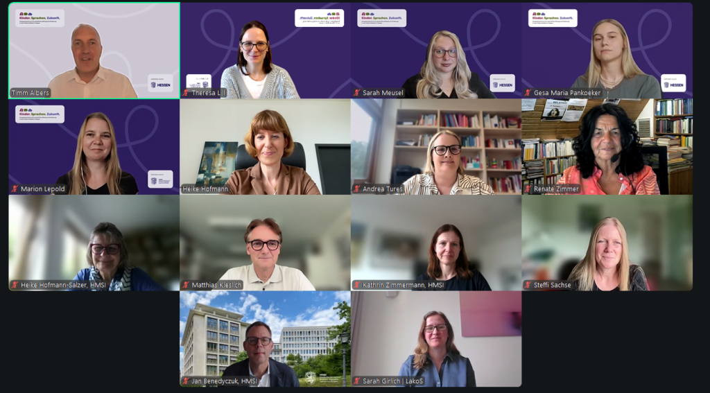 Screenshot einer Videokonferenz mit 14 Teilnehmenden, die freundlich in ihre Kameras schauen.